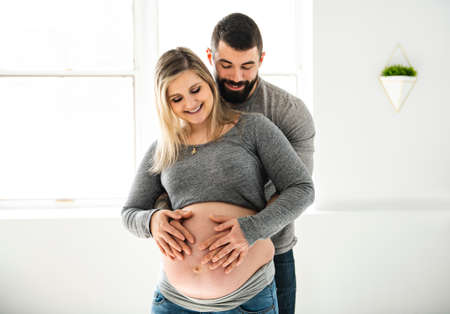 Pregnant women with her husband feeling happy at home