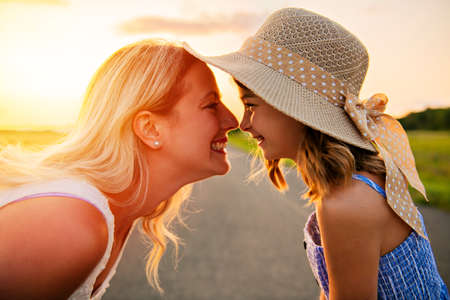 happy family at sunset. Mother and daughter having fun and playing in natureの写真素材