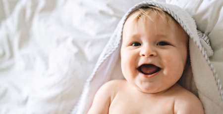 A cute Baby in white bedding at homeの写真素材