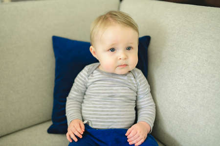 Portrait of baby boy sitting on the couch.