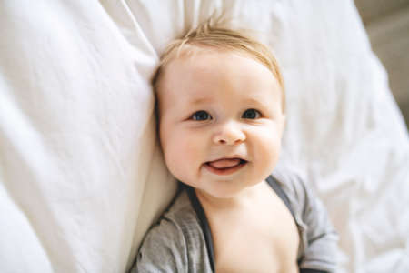A cute Baby in white bedding at home