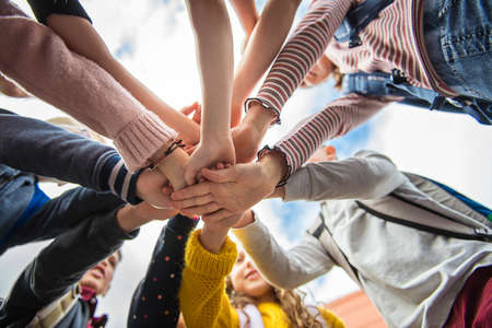 A Group of school child standing together with hand over