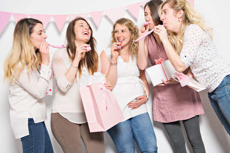 Best Friends on baby shower party celebrating giving kid stuff as presentの写真素材