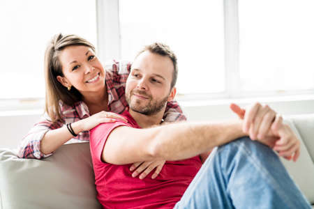 Couple sitting together on sofa at homeの写真素材