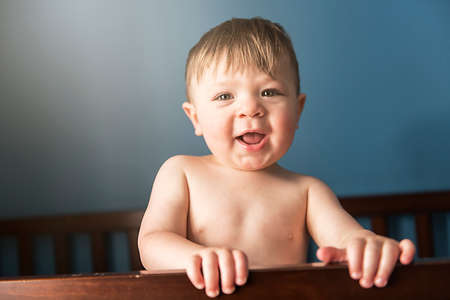 Portrait of boy standing in wood cradleの写真素材