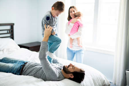four peoples family on a white bed.の写真素材
