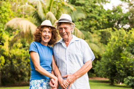 Portrait of a beautiful elderly couple standing embracing outdoorsの写真素材