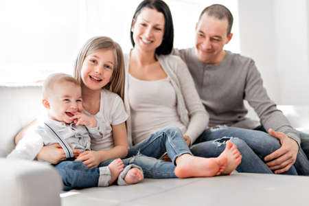 young family at home having fun on sofa
