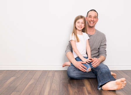 father with his daughter sit on the groundの写真素材