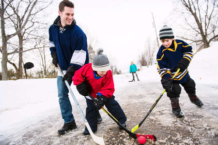 A nice Father and two sons playing hockeyの写真素材