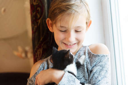 10 years old girl with kitten at homeの写真素材