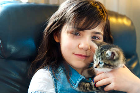 7 years old girl with kitten at homeの写真素材