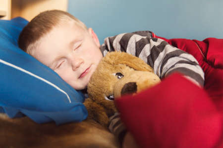 Cute 5-6 years old boy sleeping at homeの写真素材