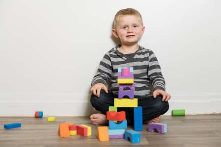 Boy building with blocks sit on the floorの写真素材