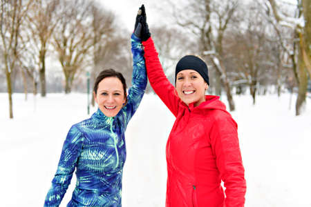 Group of friends enjoying jogging in the snow in winter