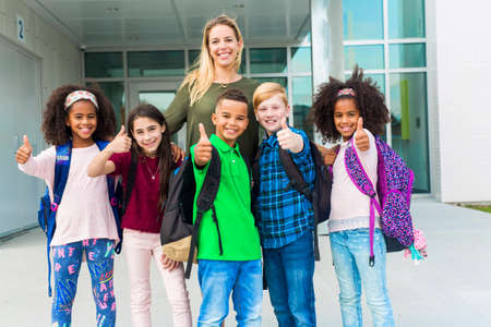 Pre teen school children with teacher outsideの写真素材