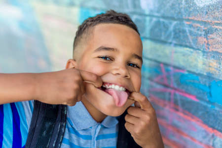 cheerful african american primary school boy with backpack