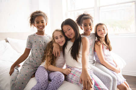 large group of her friends taking goog time on bed
