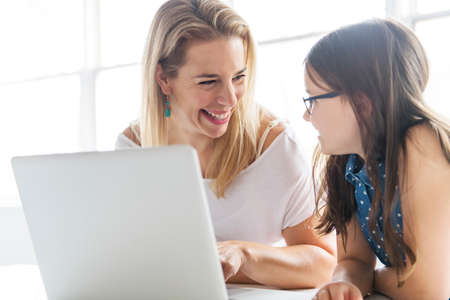 Schoolgirl researching online with the guidance of her teacher