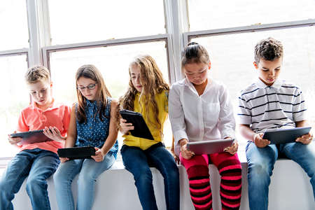 Group of curious children watching stuff on the tablet screen