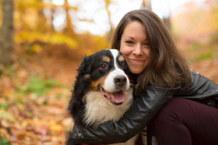 Cute girl with her Dog in Autumn park. Bernese Mountain Dog