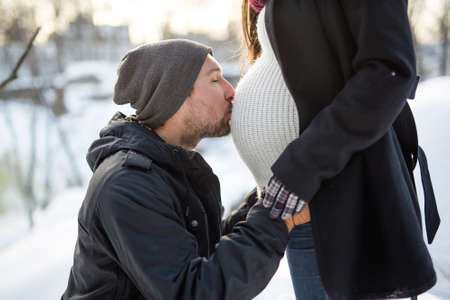 Pregnant couple have fun in winter nature
