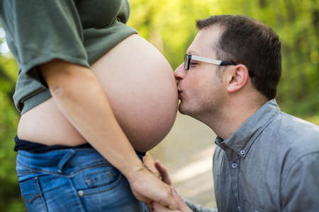 Family together in the autumn park. Woman is pregnant