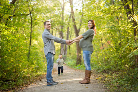 Beautiful pregnant couple relaxing outside in the park.の写真素材