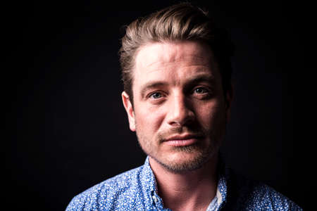 Closeup portrait of confident man on black background.