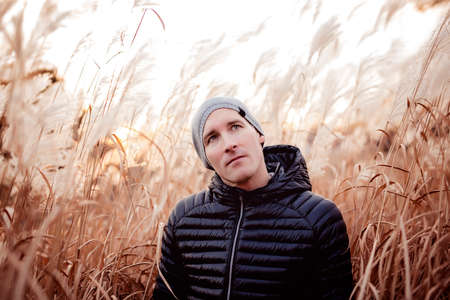men in a field at sunset season with hat