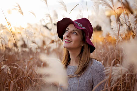 Woman in a wheat field at sunsetの写真素材