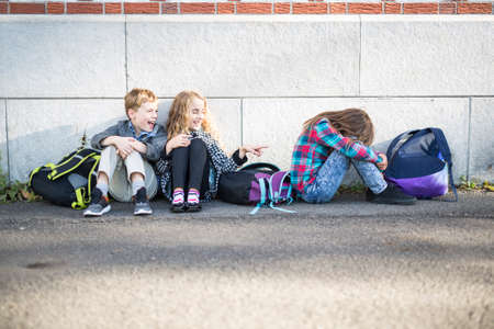 primary students outside at school standing sadの写真素材