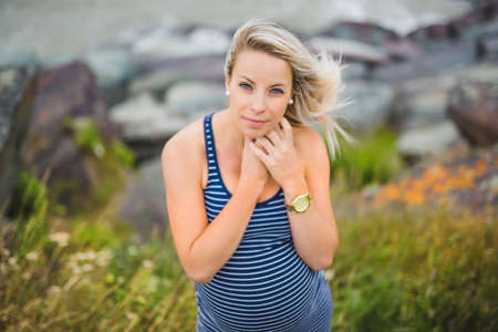 Portrait of a young beautiful blond pregnant woman on the side of the beachの写真素材