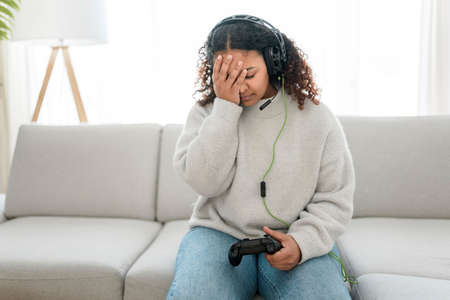 young dark haired woman in white clothes playing video games in a living room
