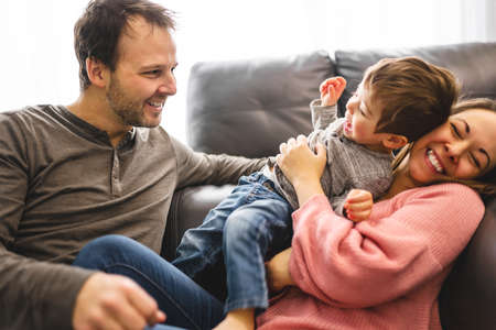 happy family mother and father having fun with child son at homeの写真素材
