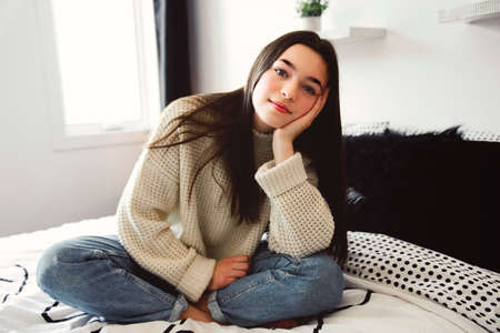 Teen spending time relaxing on bedroom at homeの写真素材