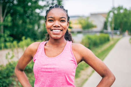 Woman runner in action outside in tree background