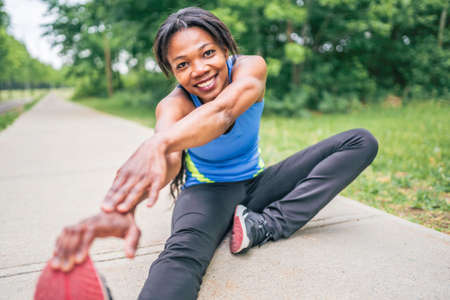 Woman runner in action outside in tree background