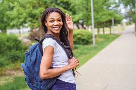 A black adult woman university student on campus with backpackの写真素材