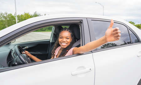 Young black teenage driver seated in her new carの写真素材