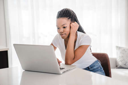 school girl sitting at home with laptop