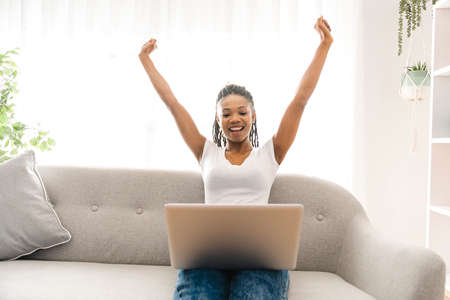 portrait of a beautiful young woman smiling with laptop and hand high