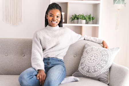 Young African American teen on a sofa in her living room relaxing