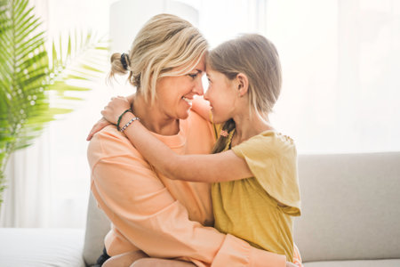 Cute child girl with his young mother at homeの写真素材