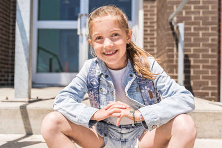 Young children girl on the school playground with backpack