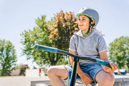 Portrait of young boy with scooter on parkの写真素材