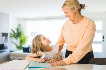 Mom helping kid with homework at home