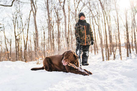 Portrait of little boy with labrador dog in winter seasonの写真素材