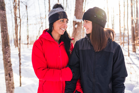 portrait of mother with his teen girl while enjoying outdoors in winter