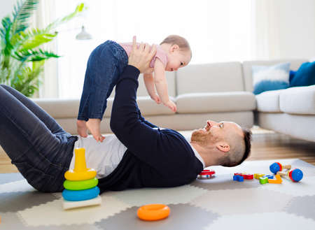 man playing with her baby in the living room
